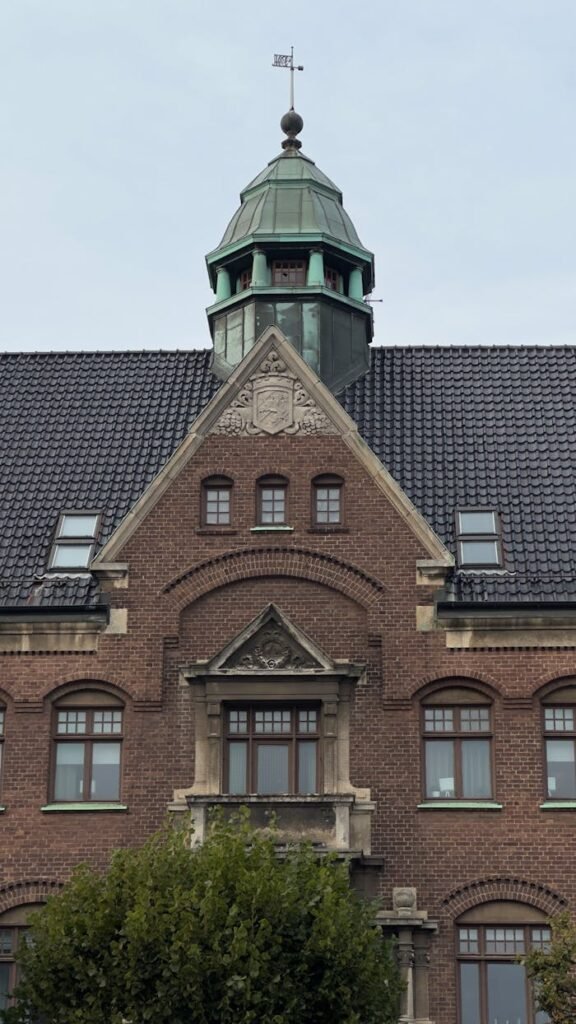 Close-up of a historic building facade with ornate details and a copper roof turret.